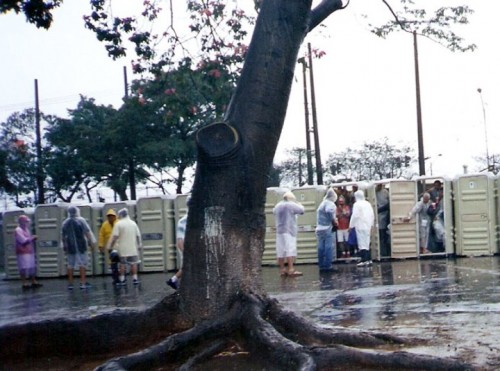 Espectadores se escondem da chuva dentro de sanitários químicos em 2003